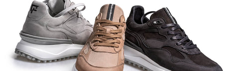 Three low-top Floris van Bommel sneakers shown together on a white studio background: a light gray pair on the left, a tan/camel pair in the center, and a dark charcoal pair on the right. The shoes have white soles.