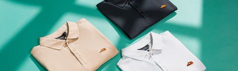 Three folded Floris van Bommel polo shirts are arranged in a beige shirt at lower left, a black shirt at upper center, and a white shirt at lower right. Each shirt has a small chest logo.