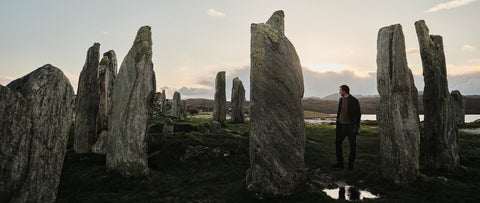 Floris van Bommel standing among ancient stone monuments in a rugged landscape