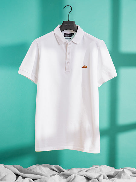 Floris van Bommel shirt. White polo shirt with a small logo on a hanger against a teal background