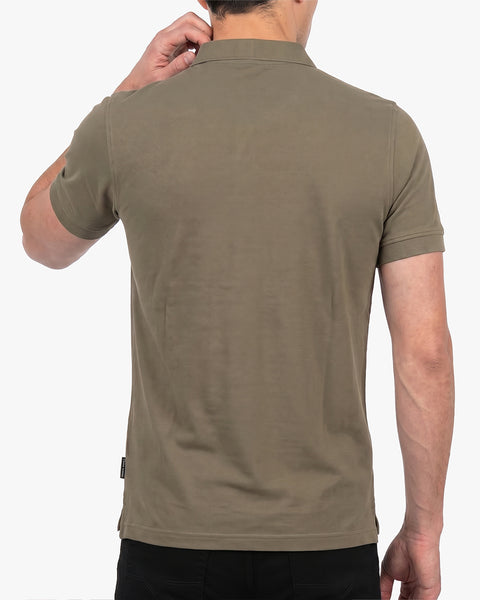 Floris van Bommel. A man wearing a short-sleeve polo shirt in a muted olive-brown colour, shown from the back against a plain light background.