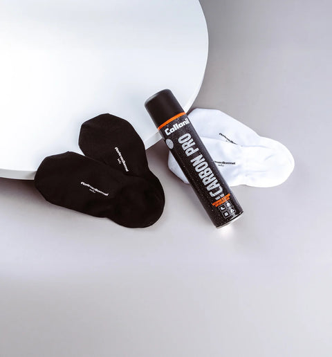 Black socks and a can of Carbon Pro on a white surface